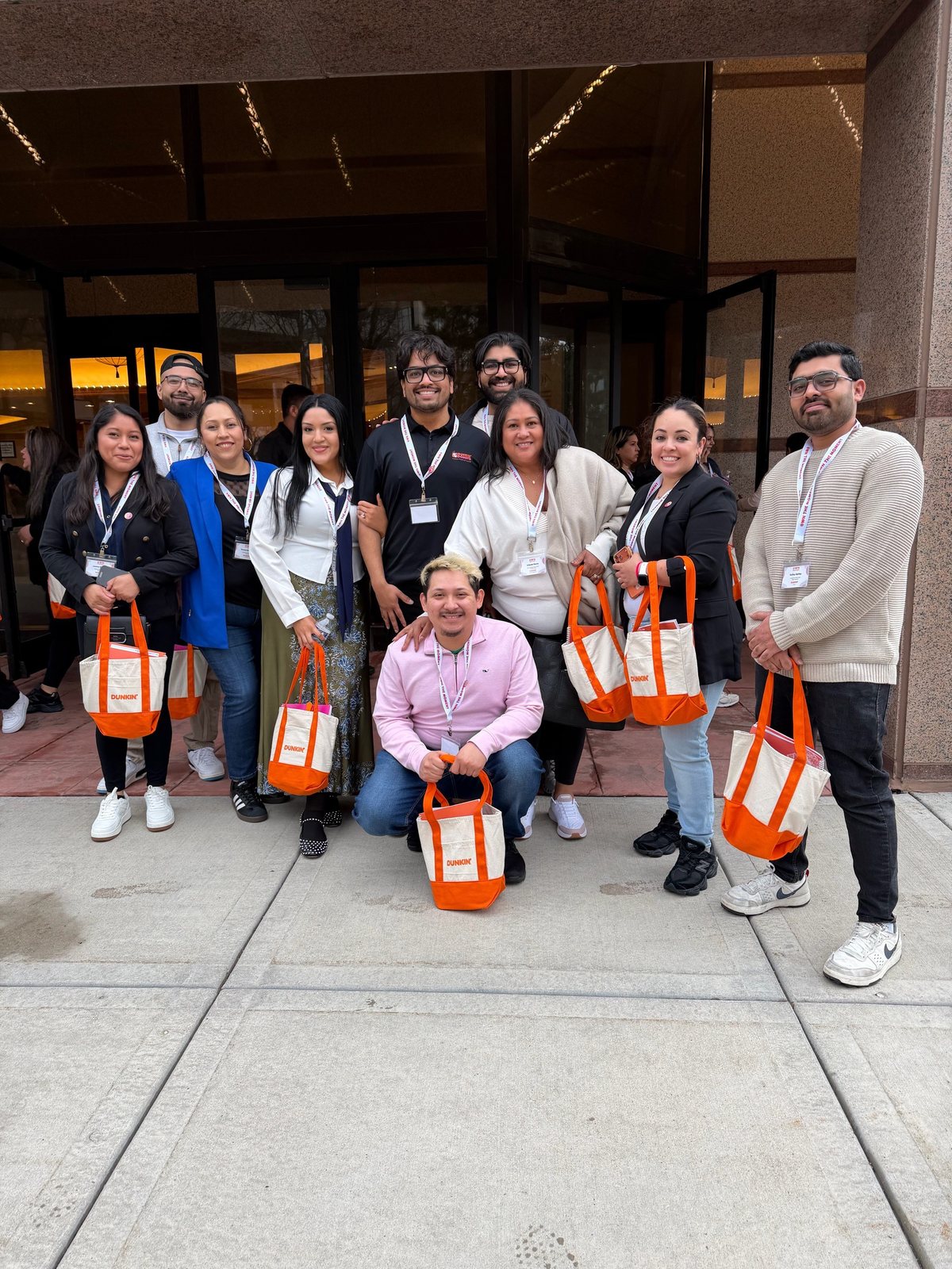The PPP Donuts Network crew together with Dunkin' tote bags at a company event